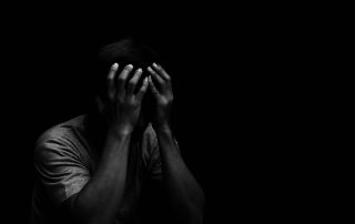 male sitting with black background