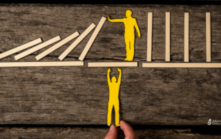 Conceptual image of a person stopping falling dominoes to prevent a relapse, while helping another person climb up, symbolizing support and intervention in recovery.