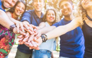 group of people putting their hands together showing benefits of residential addiction treatment