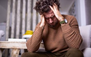 person holding head in hands showing dangers of benzo withdrawal