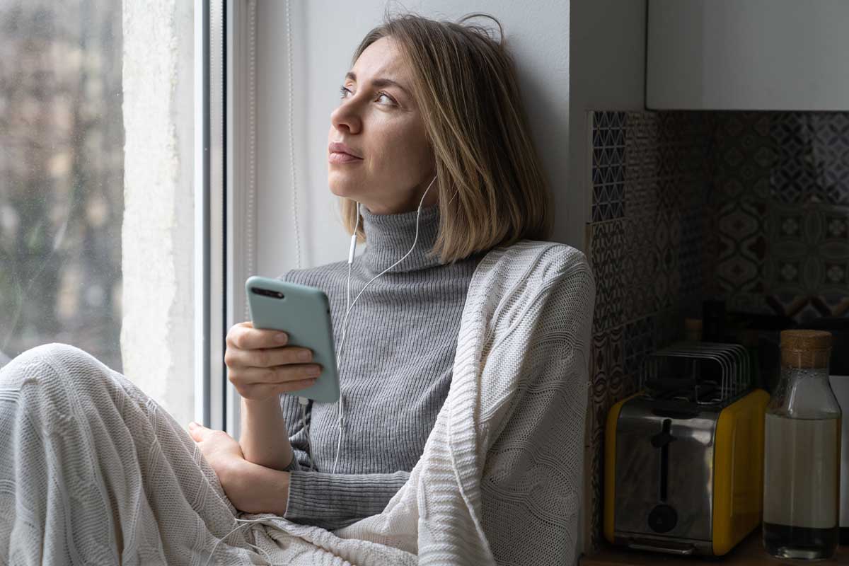 woman on her phone dealing with women's issues in addiction recovery