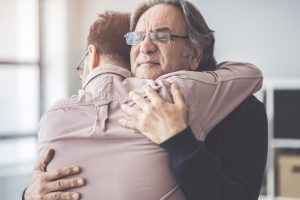 Son hugs his father during family therapy during detox