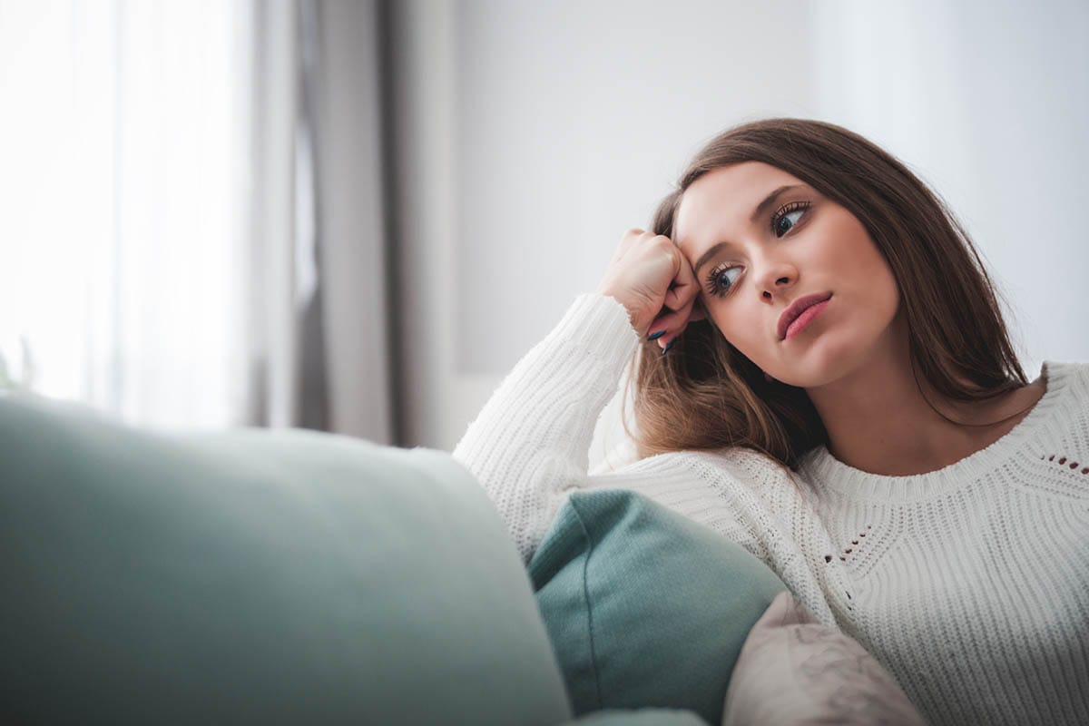 woman leaning on couch with xanax addiction