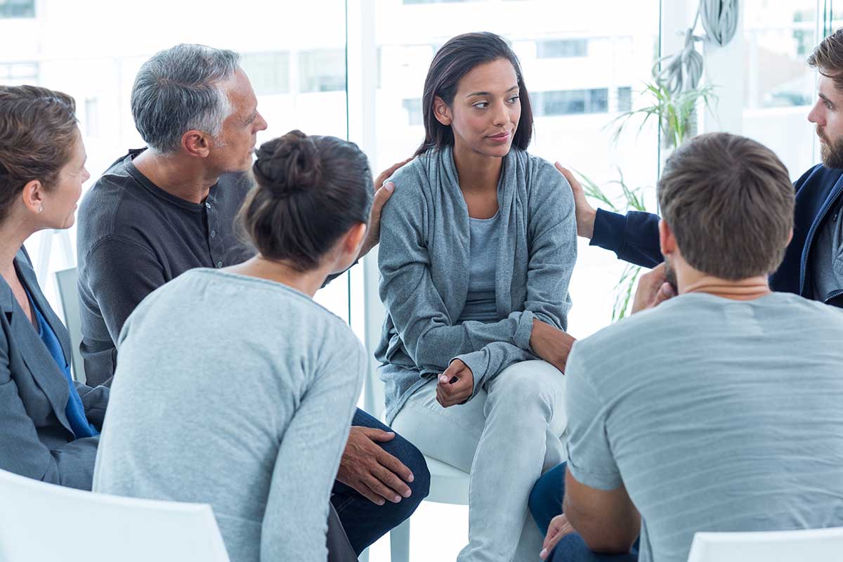 woman being comforted in group therapy