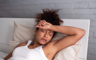 woman laying down in bed during detox - Safe to Detox from Home? concept image