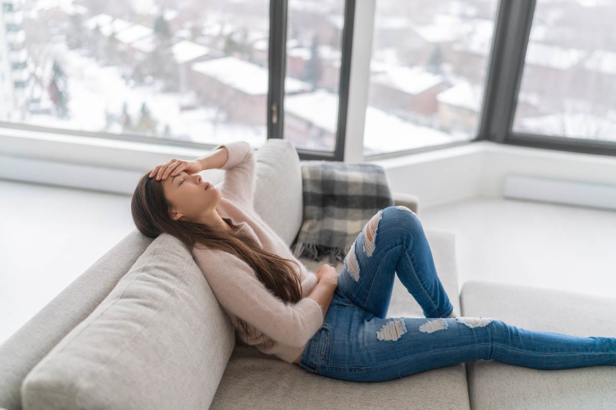Woman on couch in pain detoxing alone