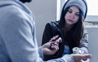 Street drugs being sold by dealer to addicted young woman