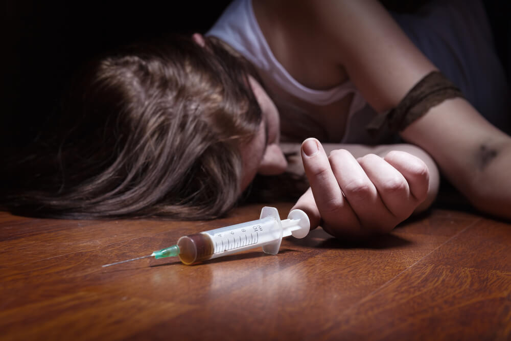 Woman Overdosed and unconscious on floor from Heroin abuse - Heroin Addiction Treatment Program concept image
