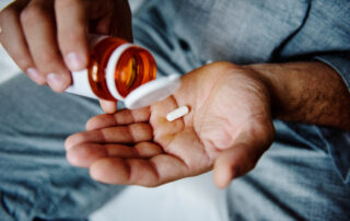 Man taking a medication prescribed by medical detox doctor for Medication-Assisted Treatment