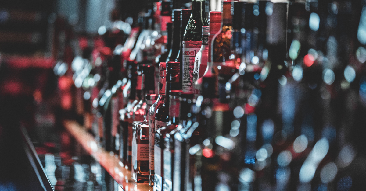 Bottles of alcohol lined up on a bar counter