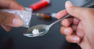 White powder being poured onto a spoon.