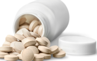 white pills spilling out of a white bottle