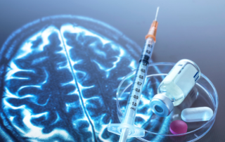 Syringe, medicine vial, and pills on a petri dish placed over an MRI scan of a human brain, symbolizing neurological research or medical treatment.