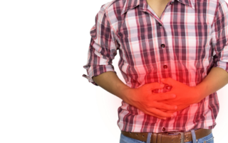 Man holds his stomach in pain, with a red bloud around his hands.