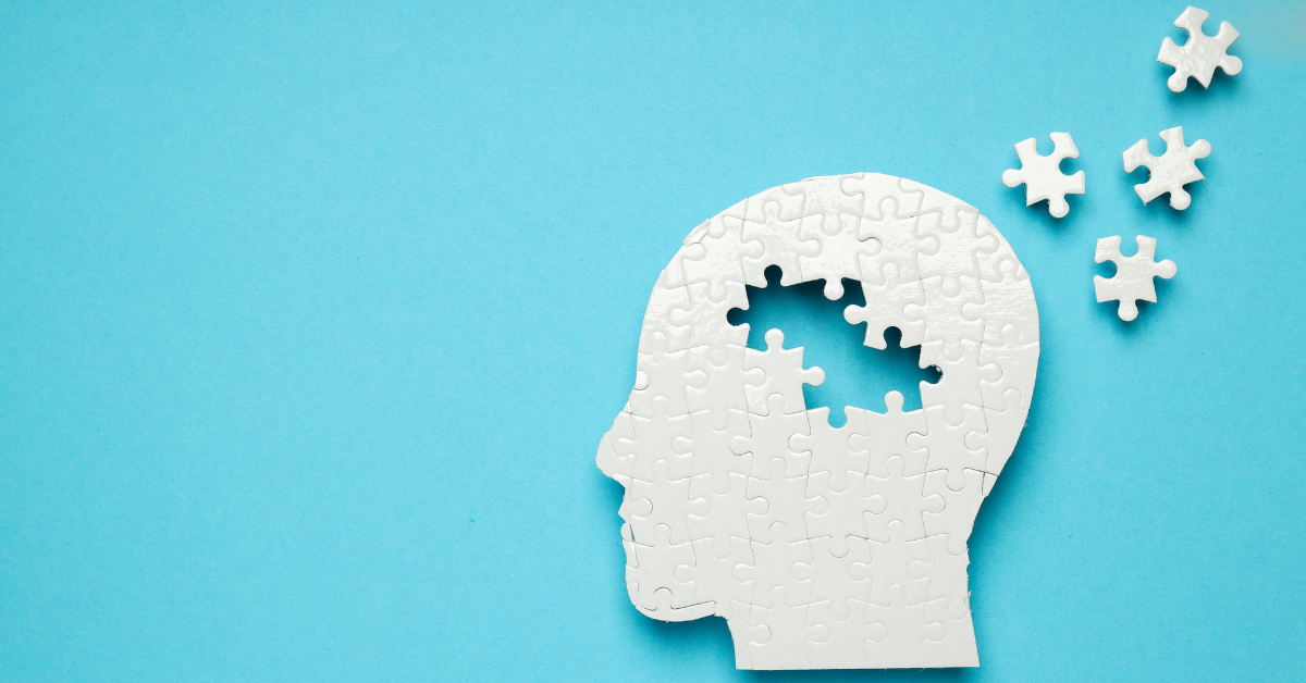 Silhouette of a head made of puzzle pieces with missing pieces floating away, symbolizing memory loss or mental health challenges.