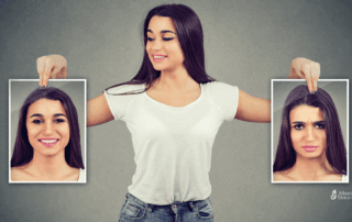 Young woman holding contrasting photos of herself—one smiling, one upset—illustrating the emotional highs and lows linked to alcohol use.